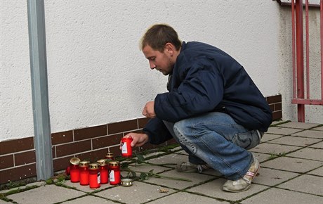 Místní zapalují svíky za obti vraedného útoku.