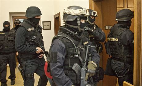 Radka Novka (uprosted za policistou) eskortuj policist k soudu.