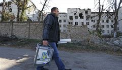 Ukrajinský volební komisa s urnou kráí kolem dom, zniených bhem obanské...