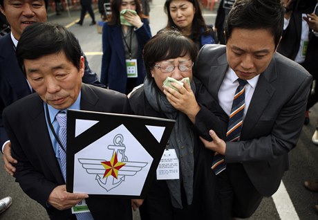Matka a otec (vlevo) zesnulého vojína Jun Sung-jua opoutjí budovu vojenského...