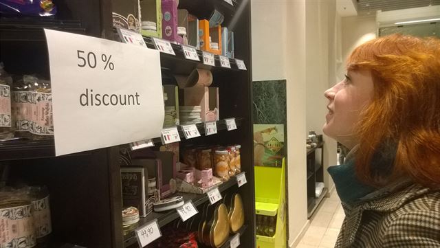 V�ude svítí cedule lákající na 50% slevy.