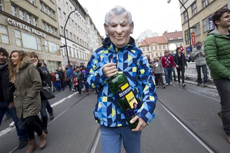 Protestujc v masce Miloe Zemana a s lahv Becherovky v rukch.
