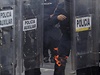 Protivládní demonstrace v Mexiku: Policista si hasí hoící botu.