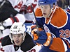 Hon na puk. Eric Gelinas (22) z New Jersey Devils a Leon Draisaitl (29) z...