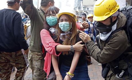 okovan demonstrantka v ulicch Hongkongu