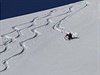 Skialpinisté sjídjí zasnené svahy cestami, které si sami tvoí v napadném...