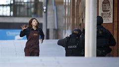 Z kavárny dr�ené neznámými úto�níky prchají dal�í lidé.