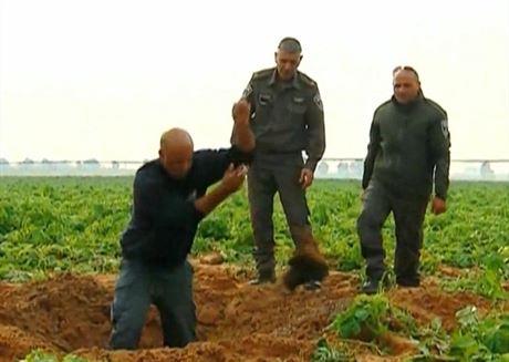 Pracovníci izraelské armády vyhrabávají kousky rakety, kterou na jejich území...