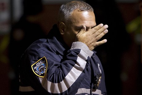 Policejní dstojník si utírá slzy na míst inu