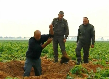 Pracovníci izraelské armády vyhrabávají kousky rakety, kterou na jejich území...
