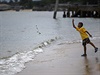 Chlapec hází ri do oceánu na uctní památky obtem tsunami