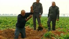 Vojci vybraj ze zem kousky rakety, kterou vyplili Palestinci