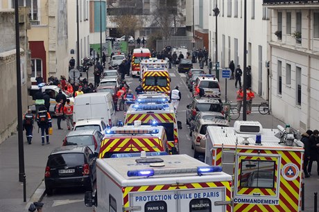 Sanitky stojí ped sídlem satirického týdeníku Charlie Hebdo, do jeho redakce...