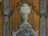 Kanelované sloupy s ionskými hlavicemi a váza zdobená kvtinovou dekorací.
