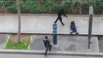 Terorist vrad jednoho z policist, kter bezmocn le na zemi.