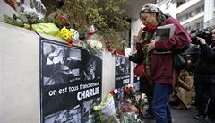 K sídlu týdeníku Charlie Hebdo p�icházejí lidé s kv�tinami a sví�kami.