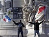 Úastníci pochodu mávají francouzskými vlajkami.