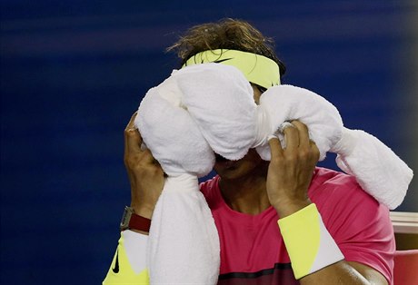 Rafael Nadal si schovává obličej do ručníku, na kurtu se mu udělalo zle.