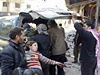 Zranné dít v náruí. Pi páteních náletech syrské armády na msto u Damaku...