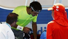 OETENÍ. Lékai zkoumají bolavé místo Rogera Federera na pravé ruce.