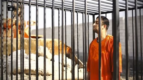 Zajatec IS, jordánský pilot Maáz Kasásba, stojí v kleci na jednom ze zábr...