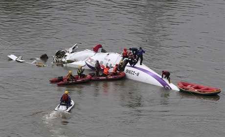 Záchranái vyproují zranné i mrtvé ze zíceného letadla.