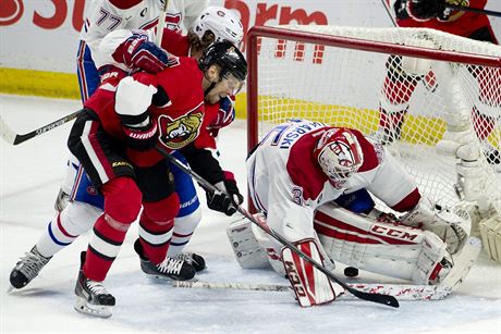 Levé kídlo Ottawa Senators Milan Michálek prosteluje blok gólmana Montreal...