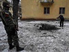 Ukrajinský voják hlídá ulici v Kramatorsku, zatímco obyvatel msta dokumentuje...