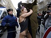 Policista se snaí zakrýt protestující polonahou aktivistku z hnutí Femen. Té...