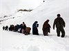 Afgánci se prodírají snhem po niivých lavinách.