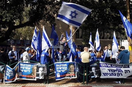 Izraelci mávají vlajkami své vlasti před volební místností v Tel Avivu.