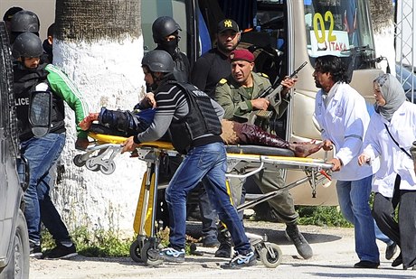 Policisté a záchranái peváejí osobu, které bhem útokv Tunisku utrpla...