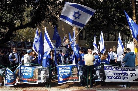 Izraelci mávají vlajkami své vlasti ped volební místností v Tel Avivu.