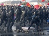 Policisté rozhánjí demonstranty, kteí házeli dlaební kostky na radnici i na...