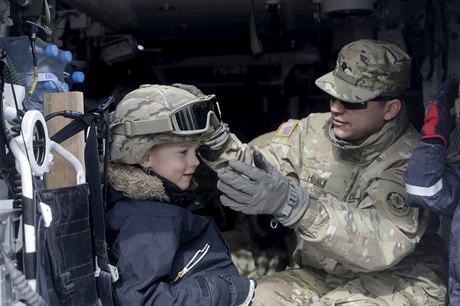 Americký voják ukazuje svou helmu litevskému chlapci.