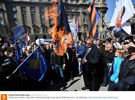 Vojislav eelj (v brýlích uprosted) pálí v centru Blehradu vlajku NATO...