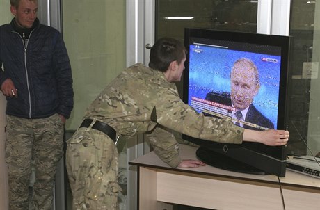 Proruský separatista na Donbasu sleduje pímý penos z televizní besedy...