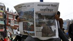 Lidé v Káthmándú tou na ulici noviny den po niivém zemtesení.