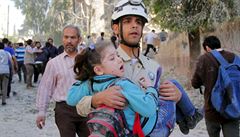 len domobrany drí v náruí syrskou dívku. Zranila ji barelová bomba, která...