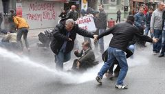 Demonstranti se snaí bránit ped policejním úderem z vodních dl.