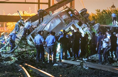 Záchranái se snaí dostat peiví ven ze zdemolovaného vlaku