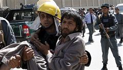 Afghánský policista nese mue zranného pi sebevraedném útoku v Kábulu.