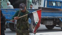 Ozbrojenec z al-kaidistick Fronty an-Nusra s roztrhanou syrskou vlajkou.