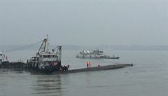 Záchranné práce na trupu potopené lodi na ece Jang-c-iang.