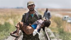 Válka v Sýrii: kurdský pemerga nese v náruí zranné dít (ilustraní snímek).
