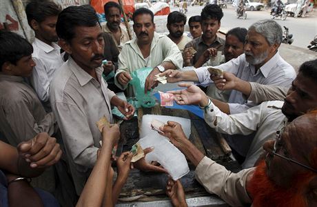 Horkem vyerpaní Pákistánci nakupují kusy ledu (Karáí).