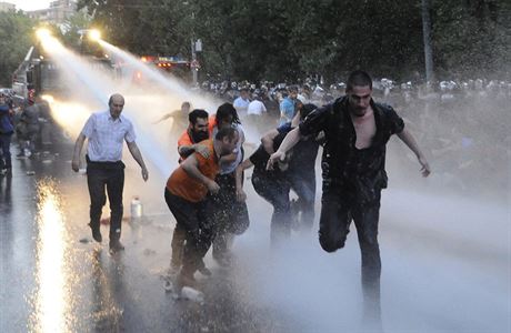 Demonstranti prchaj ped policejnmi vodnmi dly.