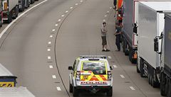 Mezi kamiony  stojícími na britské stran tunelu projídí policejní hlídky.