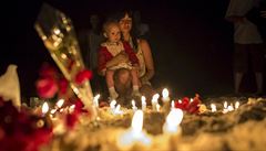 ena drí své dít vedle zapálených svící za obti teroristického útoku v...
