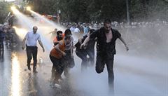 Demonstranti prchají p�ed policejními vodními d�ly.